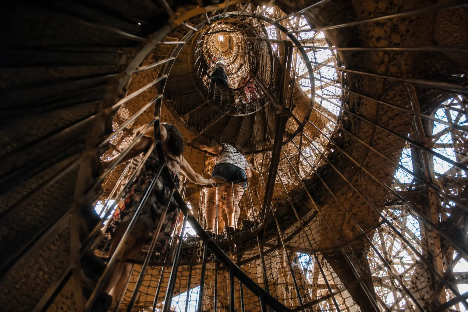 Woman climbing the spiral staircase inside the Eiffel Tower